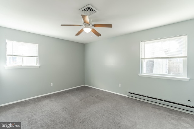 carpeted empty room featuring baseboard heating, ceiling fan, and a healthy amount of sunlight