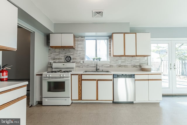 kitchen featuring sink, french doors, white range with gas stovetop, stainless steel dishwasher, and white cabinets