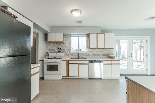 kitchen featuring black refrigerator, french doors, gas range gas stove, sink, and dishwasher