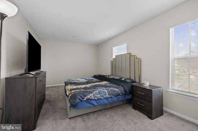 bedroom with light colored carpet and baseboards