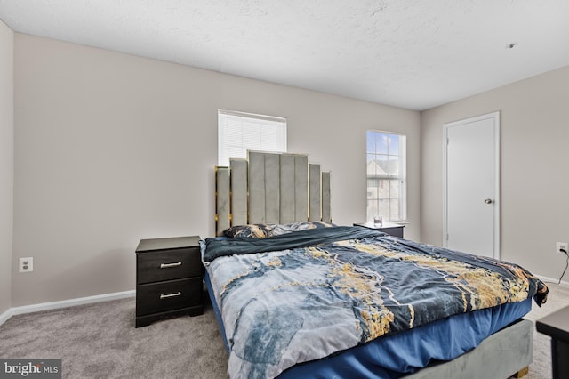 bedroom featuring carpet, baseboards, and a textured ceiling