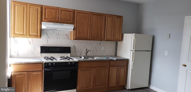 kitchen with white appliances, backsplash, light stone counters, and sink