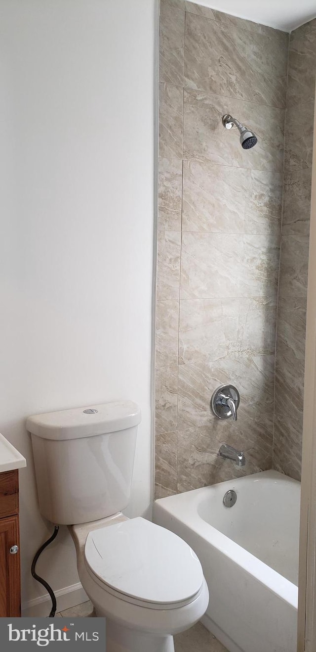 full bathroom featuring tiled shower / bath, vanity, and toilet