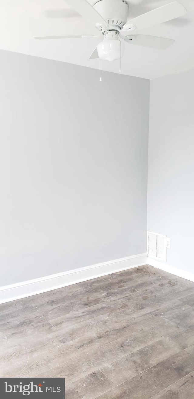 empty room with ceiling fan and light hardwood / wood-style flooring