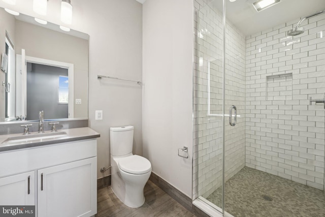 bathroom featuring vanity, toilet, hardwood / wood-style floors, and an enclosed shower