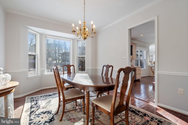 dining room with ornamental molding, dark wood-type flooring, and a chandelier