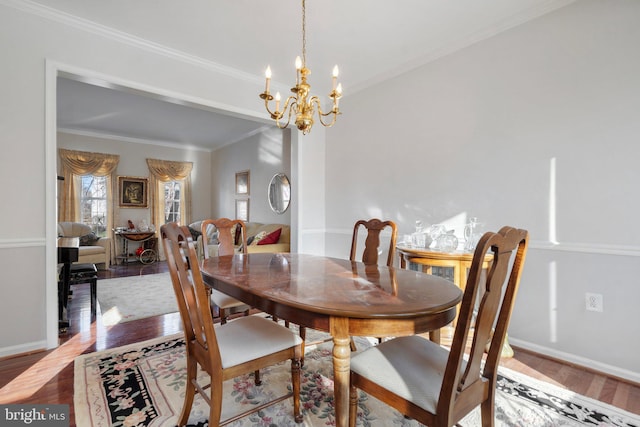 dining room featuring hardwood / wood-style flooring, ornamental molding, and a notable chandelier