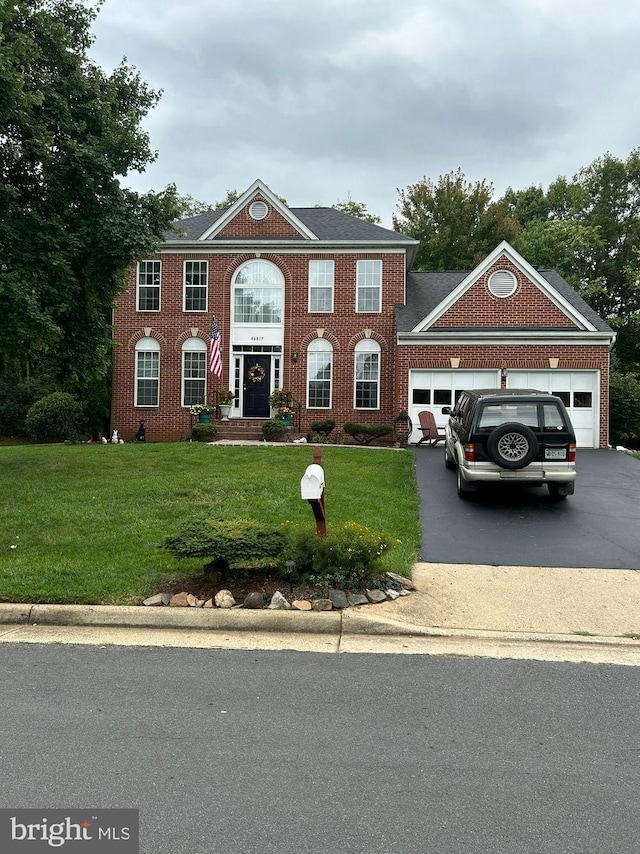 colonial home with a garage and a front lawn