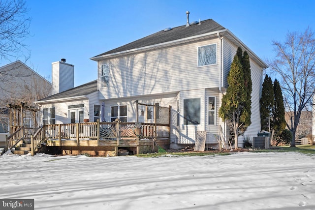 snow covered house with a wooden deck