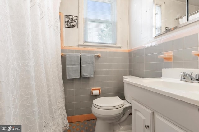 bathroom with tile walls, toilet, vanity, and walk in shower