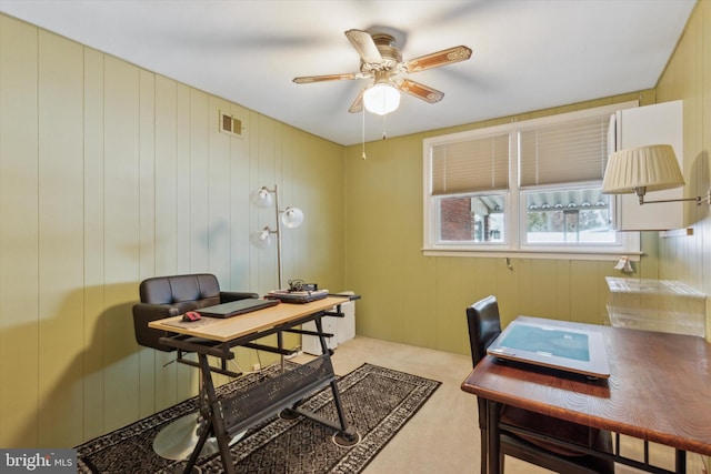 home office featuring ceiling fan and wooden walls