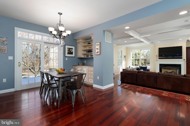 dining room featuring dark wood-style flooring, coffered ceiling, a fireplace, baseboards, and beam ceiling