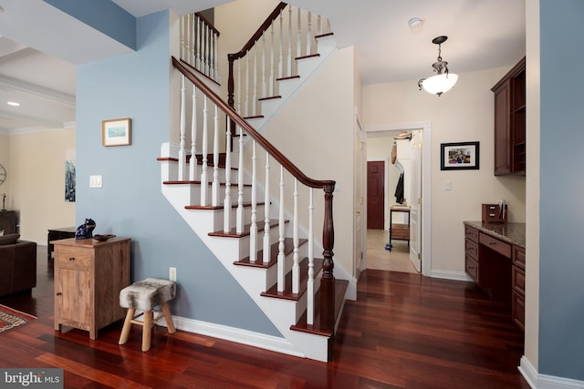 stairs with baseboards, wood finished floors, and built in study area