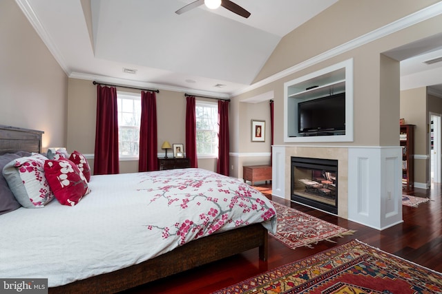 bedroom with dark wood-style flooring, crown molding, lofted ceiling, visible vents, and a high end fireplace