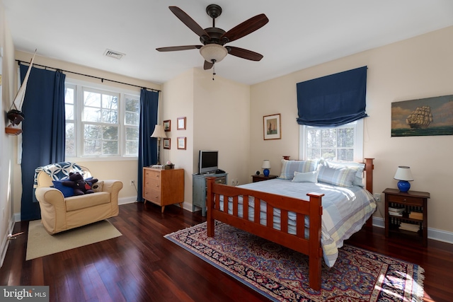 bedroom featuring a ceiling fan, visible vents, baseboards, and wood finished floors