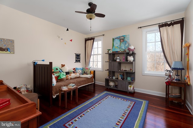 bedroom featuring ceiling fan, baseboards, and wood finished floors