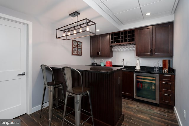 bar featuring baseboards, wine cooler, wood finish floors, indoor wet bar, and recessed lighting