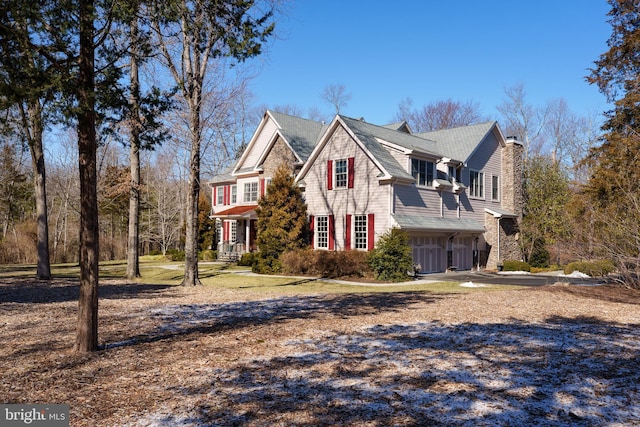 view of front of property with a garage, central AC, and a chimney