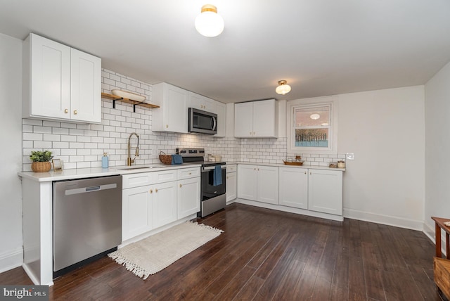 kitchen featuring decorative backsplash, appliances with stainless steel finishes, dark hardwood / wood-style flooring, sink, and white cabinets