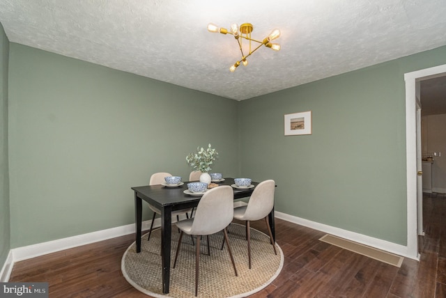 dining room with a textured ceiling and dark wood-type flooring