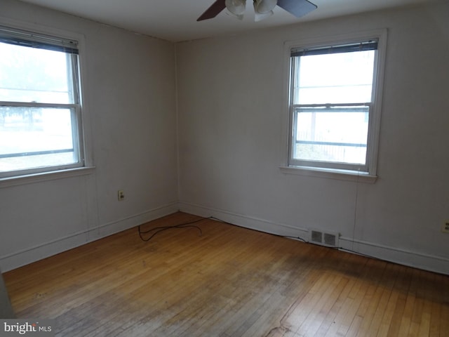 unfurnished room featuring ceiling fan, a wealth of natural light, and light hardwood / wood-style floors