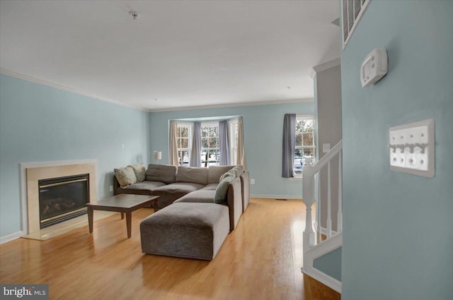 living room featuring light wood-type flooring and crown molding