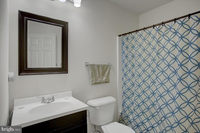 bathroom with toilet, vanity, and a shower with curtain