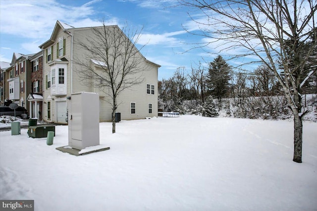 view of snowy exterior featuring a garage