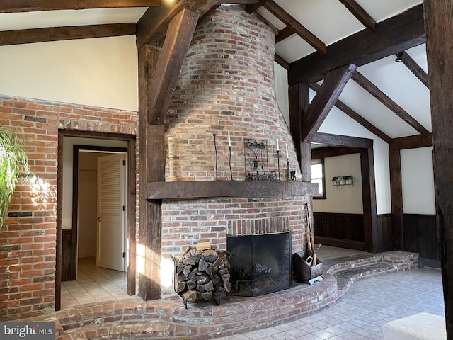 unfurnished living room featuring a fireplace, light tile patterned floors, wooden walls, and vaulted ceiling with beams