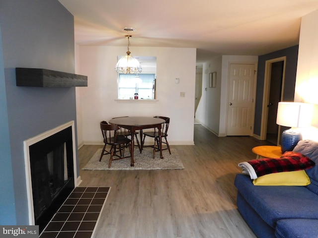 living room featuring a fireplace, hardwood / wood-style flooring, and a notable chandelier