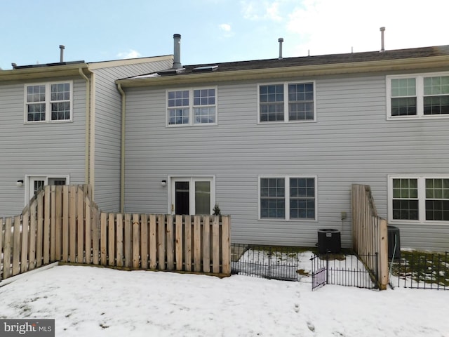 snow covered back of property with central AC unit