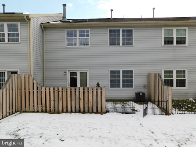 snow covered rear of property with central air condition unit