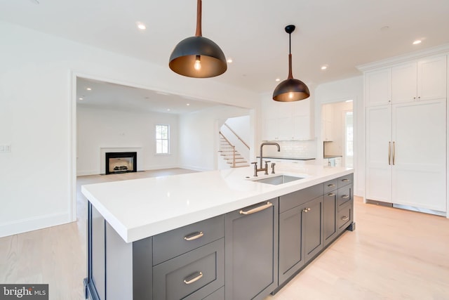 kitchen with decorative light fixtures, white cabinetry, tasteful backsplash, and sink