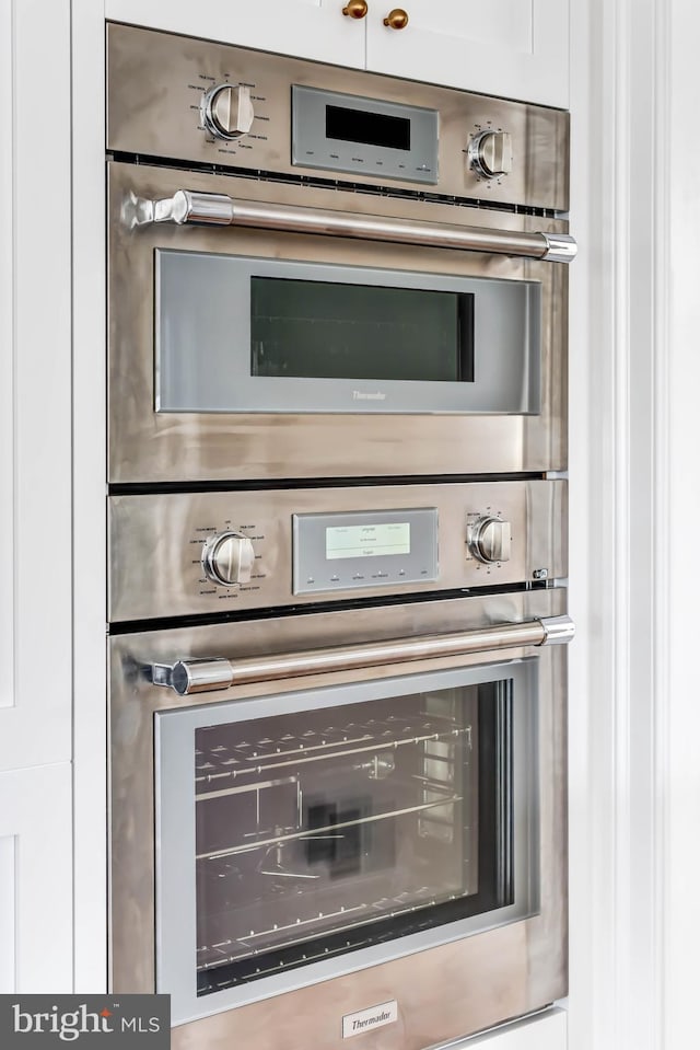 interior details with white cabinetry and double oven