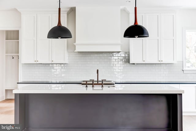 kitchen featuring tasteful backsplash, white cabinetry, and hanging light fixtures