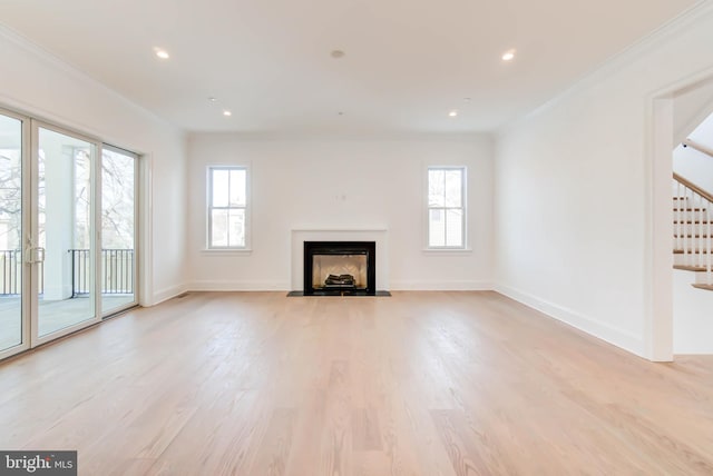 unfurnished living room with light wood-type flooring and ornamental molding