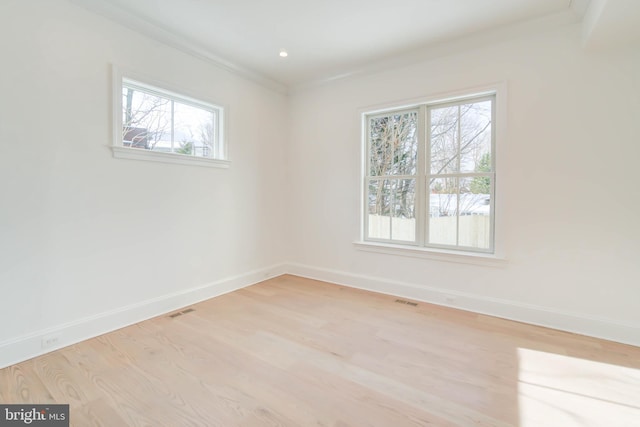 spare room featuring light hardwood / wood-style flooring and crown molding