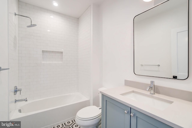 full bathroom featuring vanity, tiled shower / bath combo, and toilet