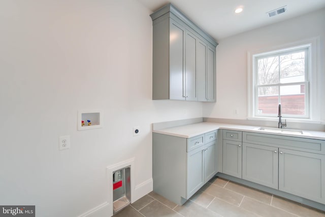 laundry area with cabinets, hookup for a washing machine, electric dryer hookup, sink, and light tile patterned floors