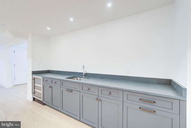 kitchen featuring gray cabinetry, sink, and beverage cooler