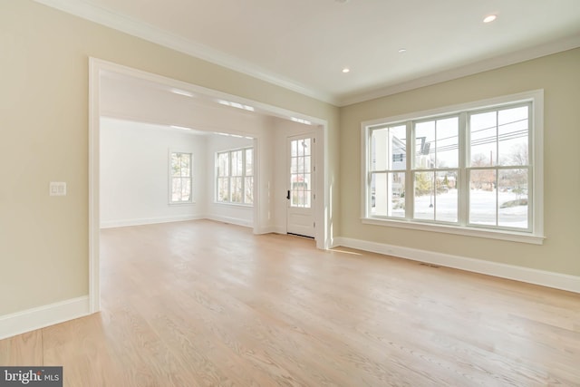 interior space featuring light wood-type flooring, plenty of natural light, and ornamental molding