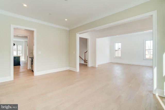 spare room with light wood-type flooring and ornamental molding