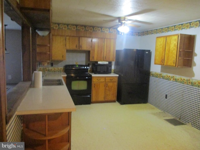 kitchen with kitchen peninsula, ceiling fan, sink, and black appliances