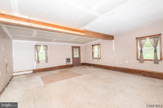 spare room with heating unit, concrete flooring, and a baseboard radiator