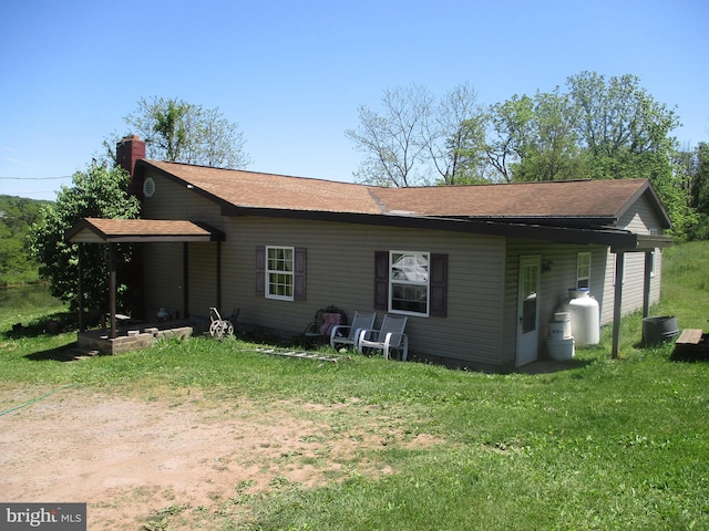 rear view of property featuring a lawn