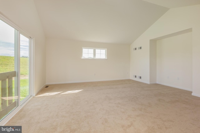 empty room with vaulted ceiling and light colored carpet