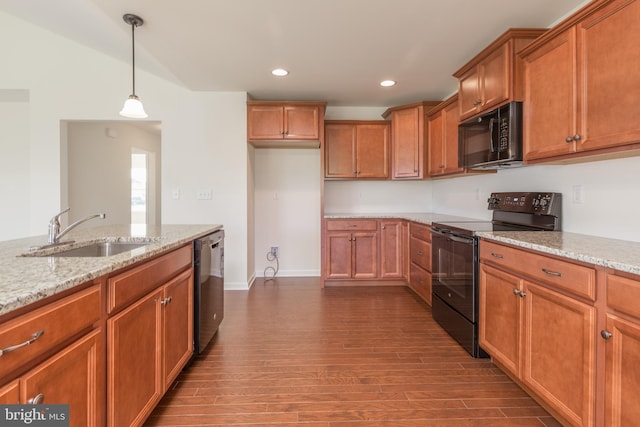 kitchen with black appliances, hanging light fixtures, light stone countertops, dark wood-type flooring, and sink