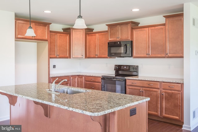 kitchen with light stone counters, decorative light fixtures, black appliances, and sink