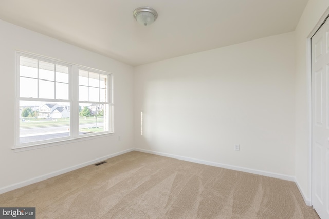 spare room featuring light colored carpet