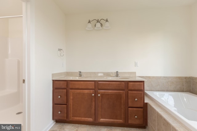 bathroom with tile patterned floors, tiled tub, and vanity